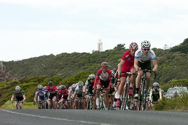 The peloton give chase to a leading group along the foreshore in Devonport.