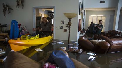 Survivors survey the damage to their flooded home in Houston