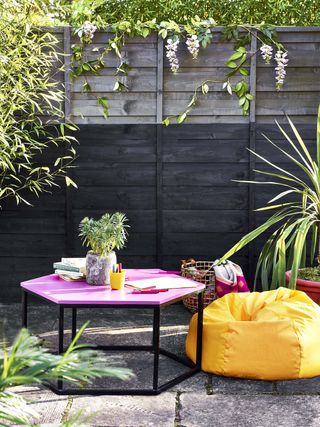 two tone painted fence and colourful painted outdoor table