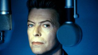 David Bowie between microphones looking directly into the camera. 