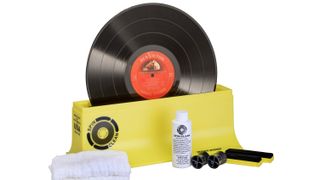 Gelbes Spin-Clean Schallplattenreinigungssystem mit Zubehör auf weißem Hintergrund