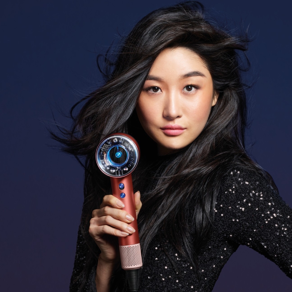 Model holding a Dyson supersonic in rose