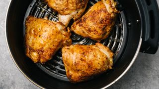 chicken thighs cooking in the air fryer
