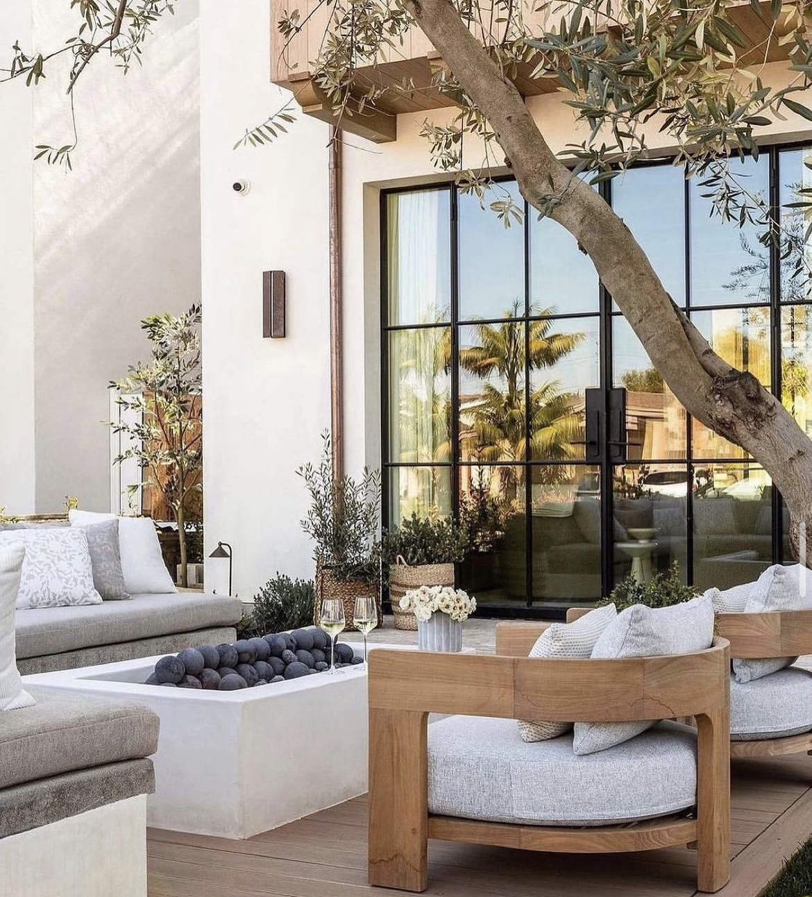 outdoor living room with firepit and accent chairs by Garden Studio Design