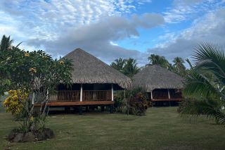 Two thatched roof bungalows at the secluded Fare Tiaia Beach property in Moorea