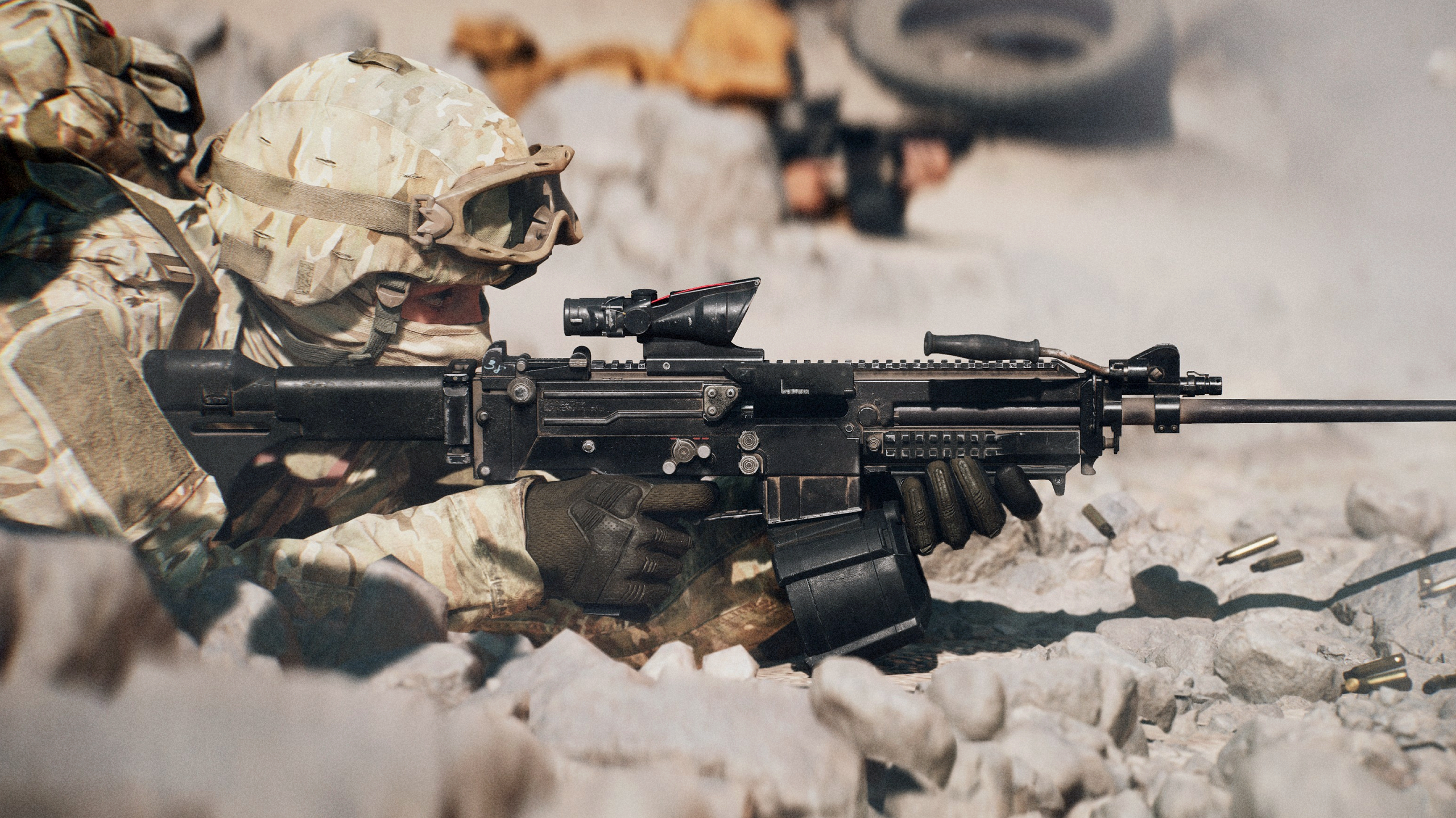 Battlefield 6 beta feedback: A side-on image of a soldier wearing full gear prone with a scoped LMG amongst rocks and other debris. 