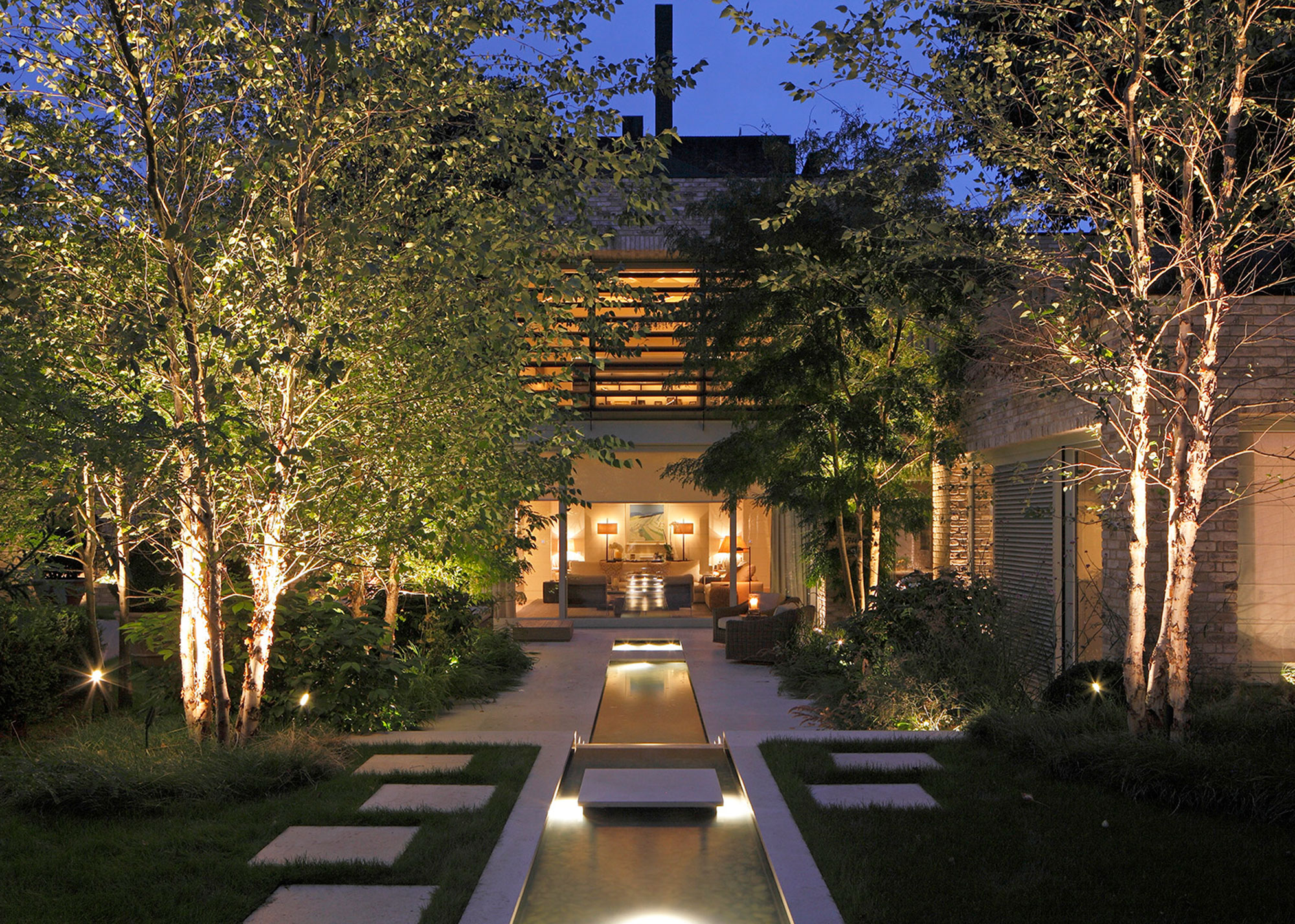 garden with layered exterior lighting and channel water feature