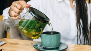 woman pouring herself a mug of peppermint tea
