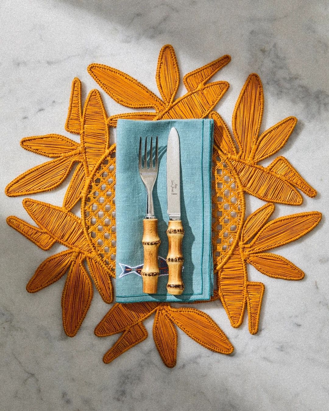 A series of sculptural rattan decorative items, including place mats, cake stands, laundry baskets, lights, napkin rings, and storage units.