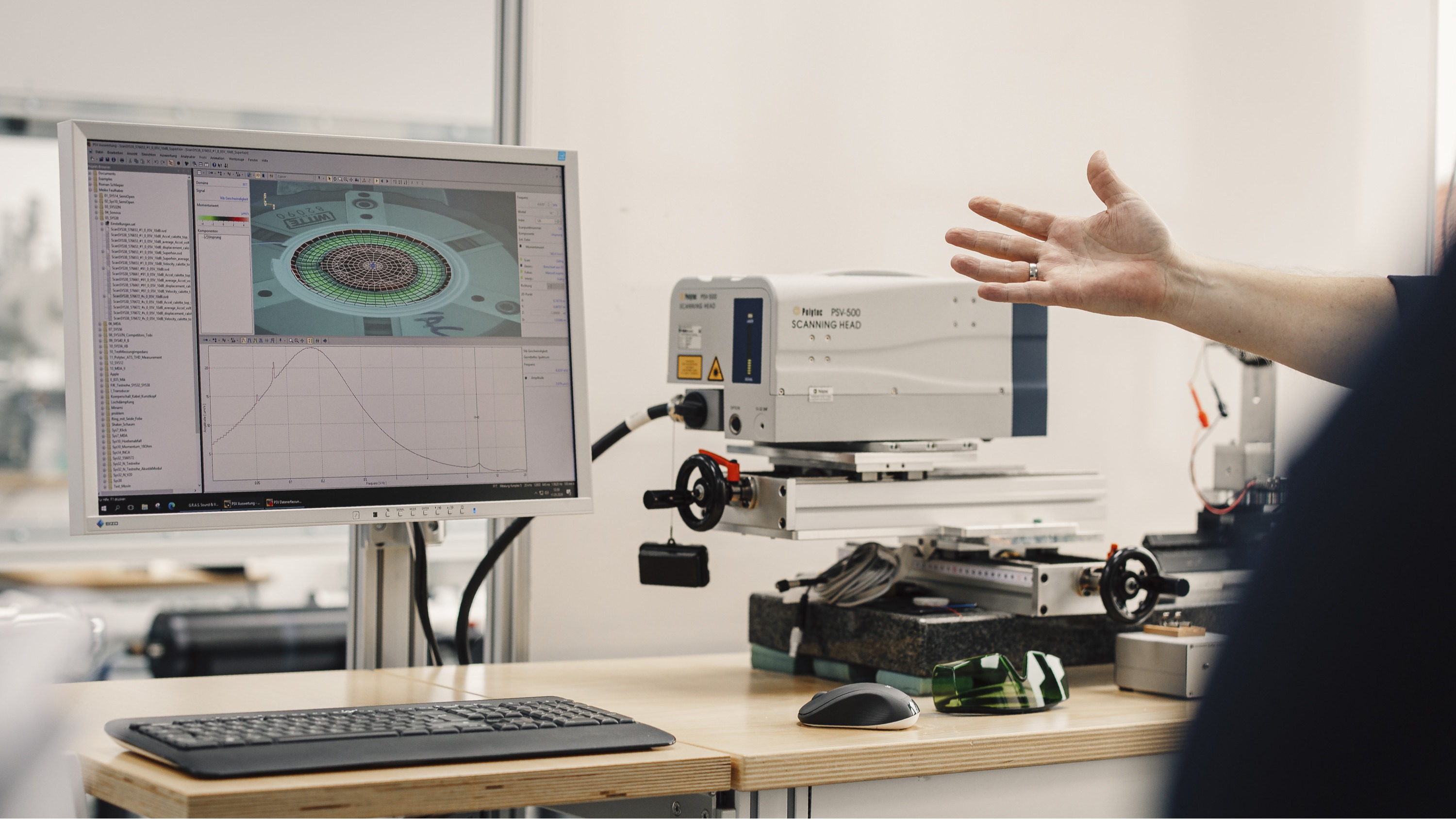 Sennheiser factory tour featuring a computer screen and laser measuring drive unit waveguides