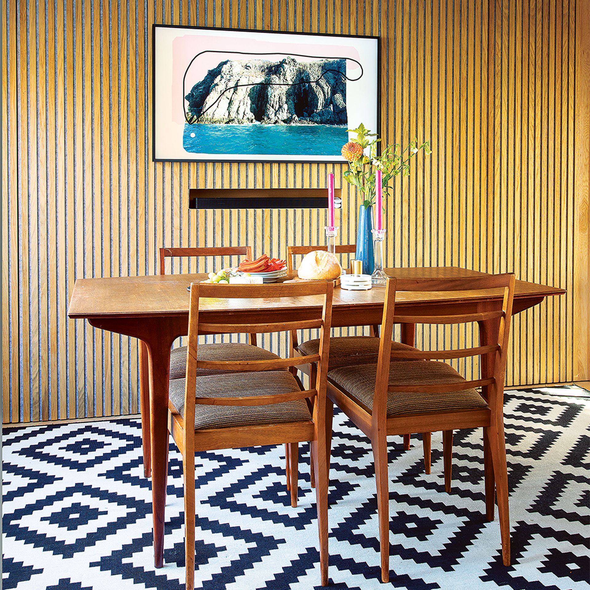 dining area with wood veneer feature wall and wooden dining table and chairs and television