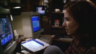 Sandra Bullock sits in front of a computer screen looking intently in The Net.