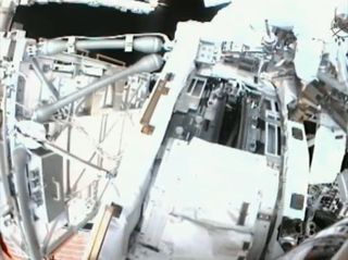 This view from a spacewalker helmet camera shows the International Space Station's port side Solar Alpha Rotary Joint (gear in center), a huge gear that turns the station's port solar arrays, during a May 22, 2011 spacewalk by astronauts Andrew Feustel and Mike Fincke.