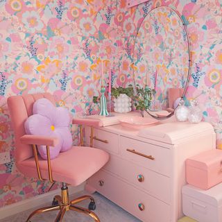 Pink bedroom with pink wallpaper and dressing table.