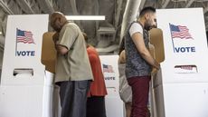Two men in voting booths.