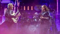 (L-R) Alex Lifeson, Anika Nilles, and Geddy Lee perform onstage earlier this month, at the Dickies Arena in Fort Worth, Texas