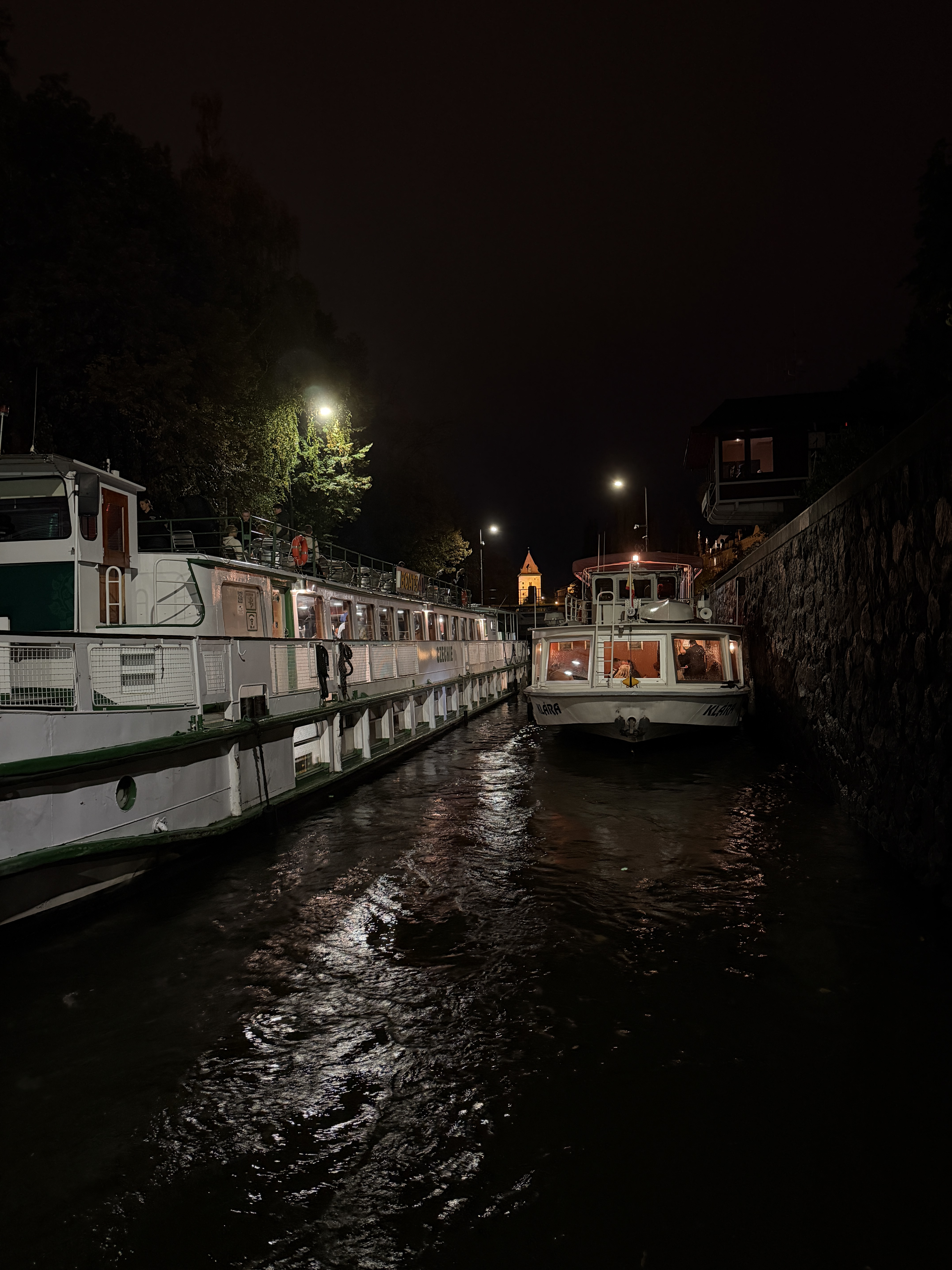 Two boats in the Vltava river at night