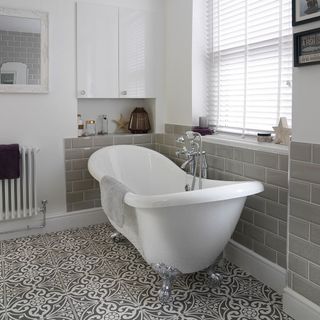 bathroom with white and grey brick wall and bathtub