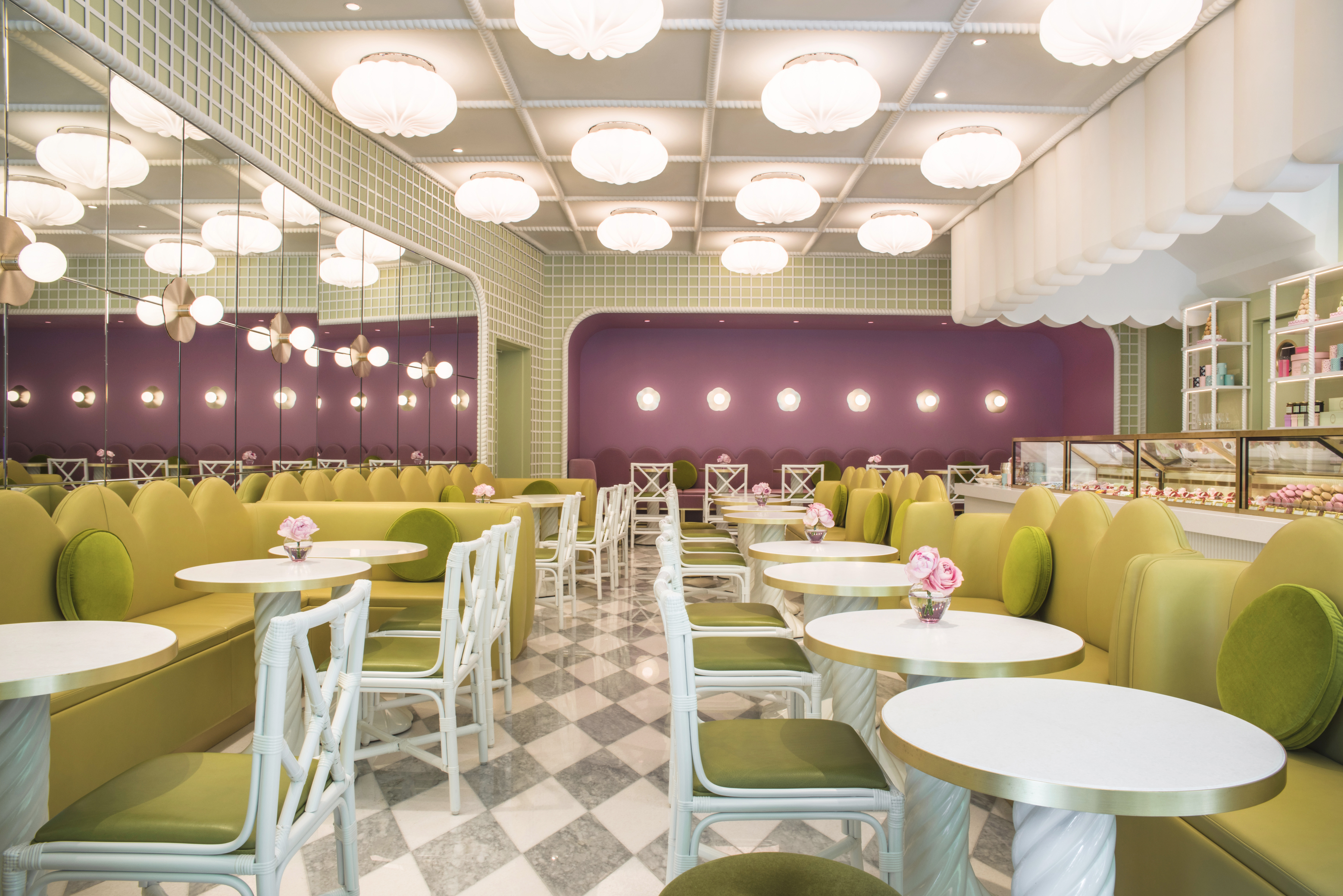 A mirrored diner-style restaurant in a lily-pad green and soft mauve colour palette, with floral lighting design.