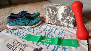 Image shows a green Meglio-Latex Free Resistance Band next to running shoes, a weight and a yoga block.