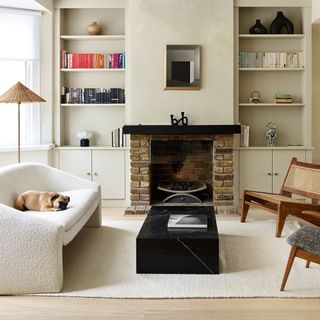 Neutral living room with built-in alcove storage each side of a fireplace