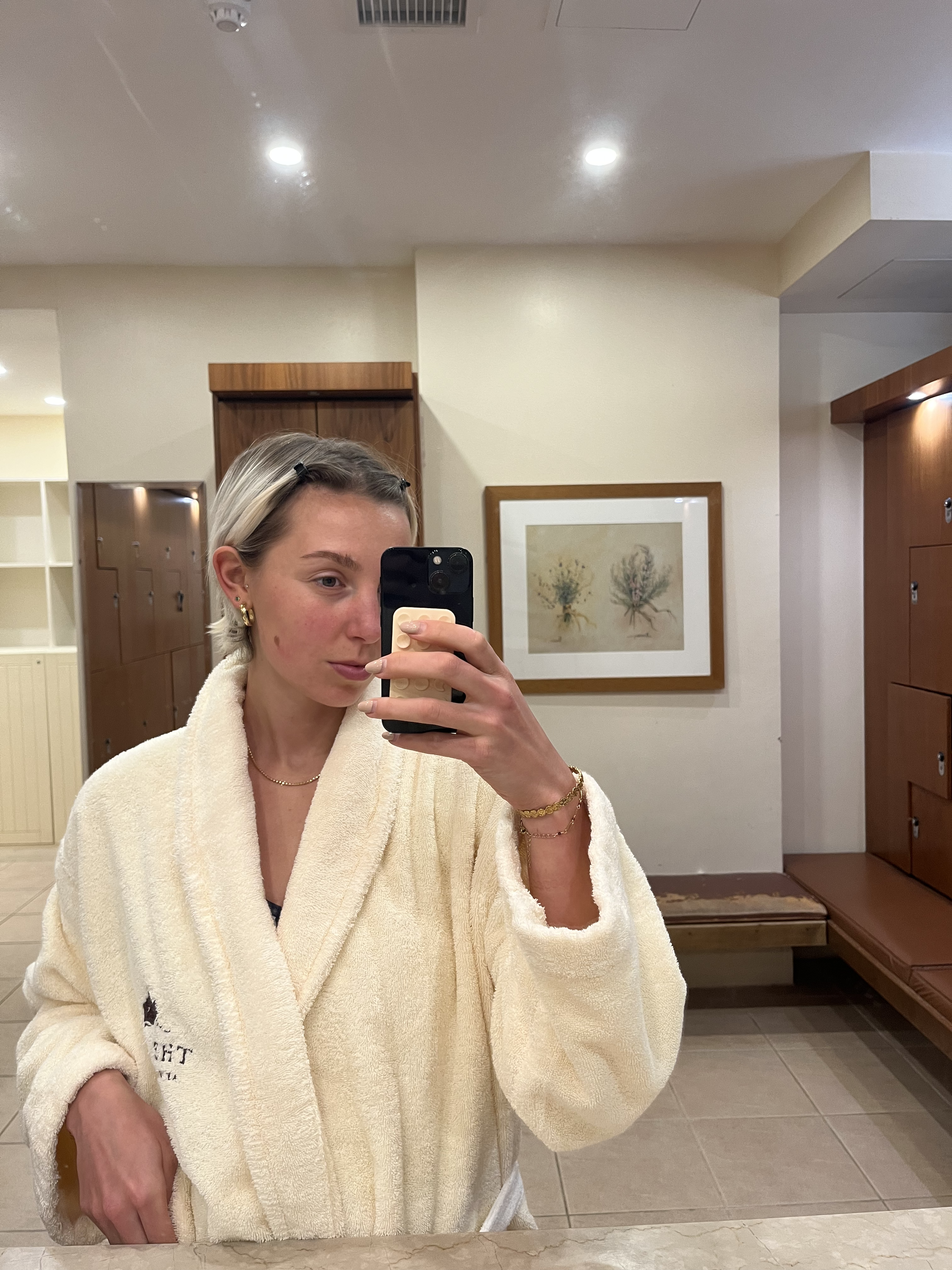 A woman taking a mirror selfie in swimming pool changing rooms