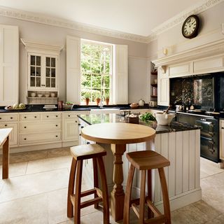 kitchen area with marble work top and wooden table with stool chair