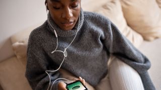 Young woman breathing deeply with app open on phone