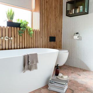 bathroom with white wall tile bathtub and brick flooring