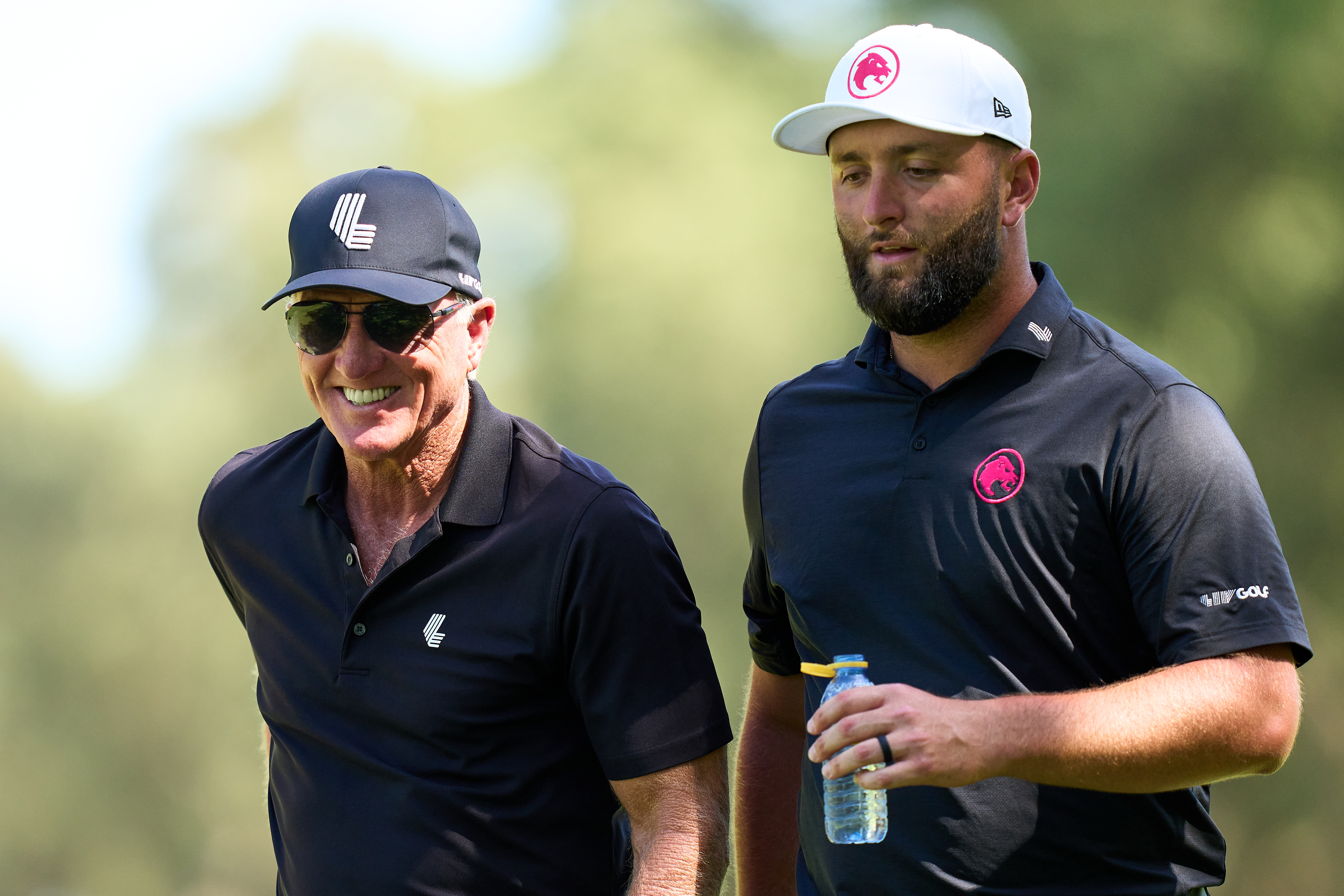 Greg Norman and Jon Rahm walk alongside each other