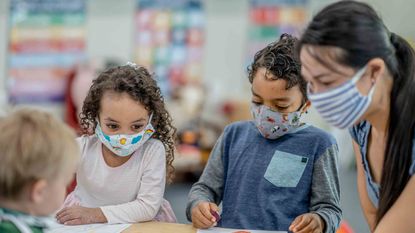 Kids at daycare with daycare associate in masks