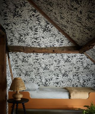 loft bedroom with wallpapered sloped ceilings
