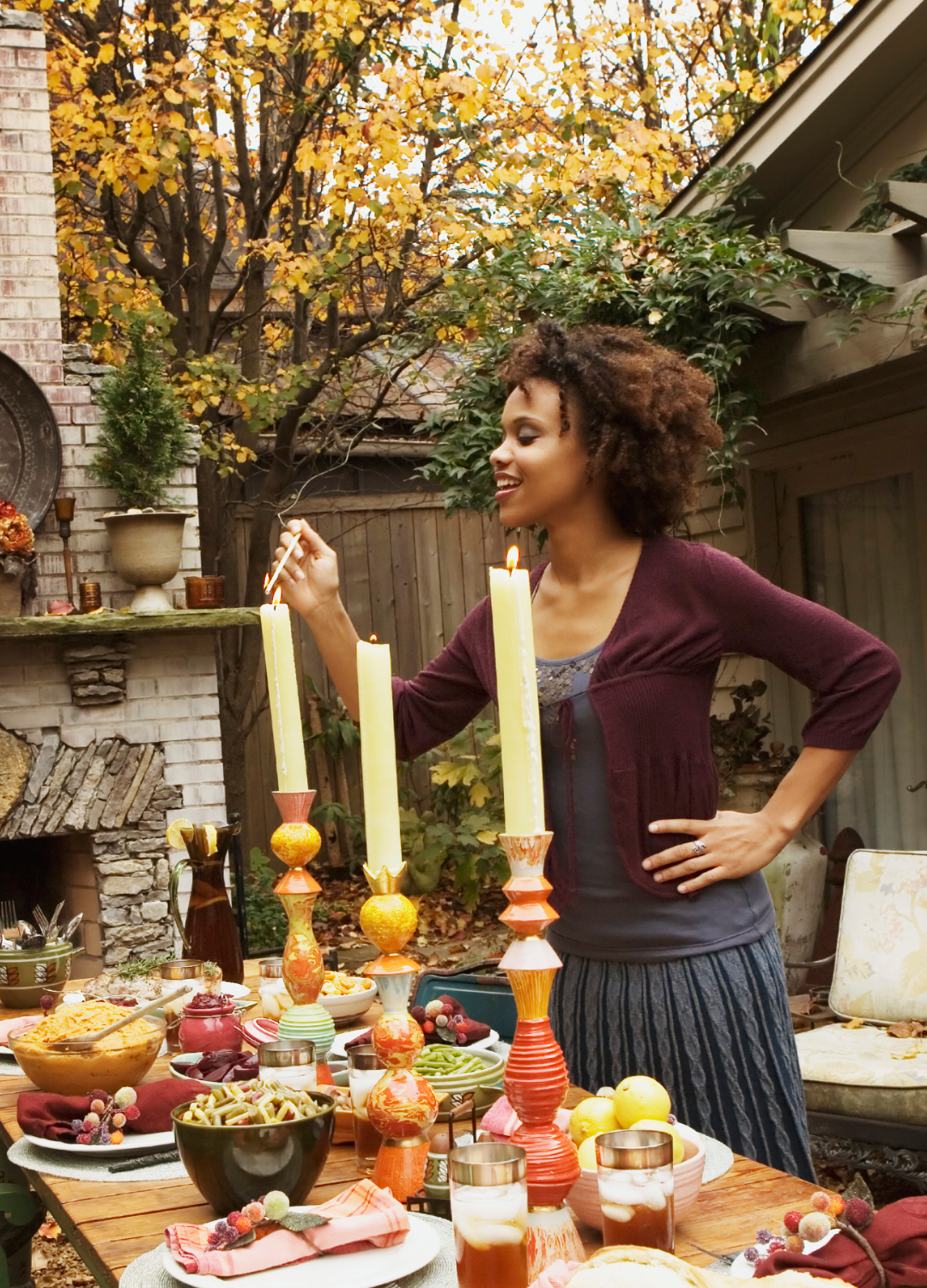 A woman lighting candles for a dinner party