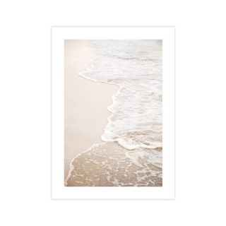 A wall art print with golden sands and the sea washing over it