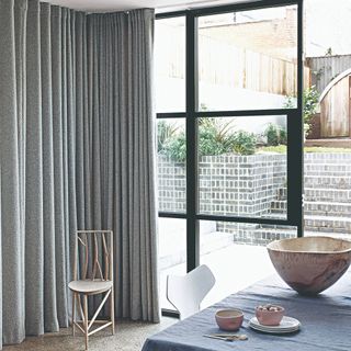 Long pleated curtains covering half of ceiling to to floor windows