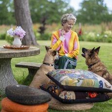 Woman in colourful tie-dye jumper and two dogs 