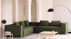 green corduroy sectional couch in a minimalist living room