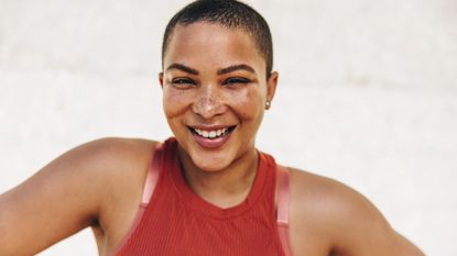 How much do I need to workout to see results: A woman smiling after her workout
