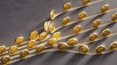Gold dollar coins move along multiple branching tracks.