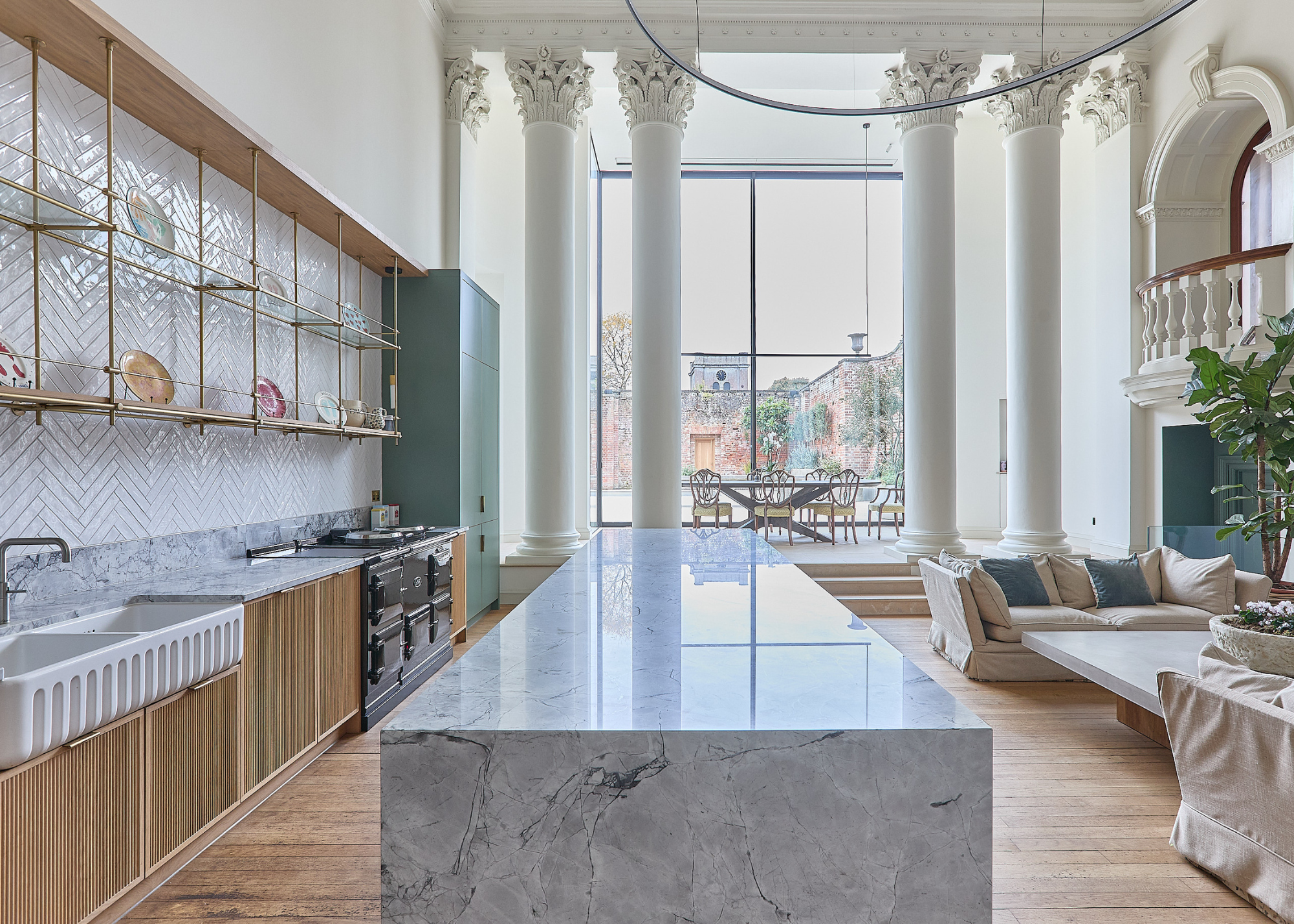 A grand architectural broken-plan setting with four floor-to-ceiling decorative pillars and a modern interior for contrast