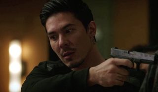 Zhou Cheng holding gun on iron fist