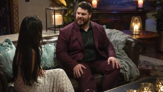 Brett Harris sits on a couch talking to Jenn Tran during The Bachelorette's Season 21 premiere on July 8, 2024.