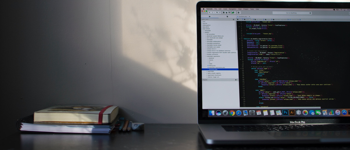 Macbook on a desk with coding displayed on screen