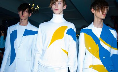 three male models wearing white yellow and blue tops