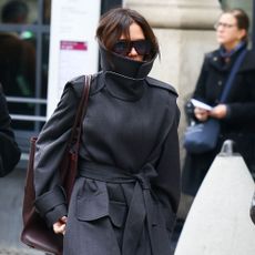 Victoria Beckham wears a funnel neck coat.