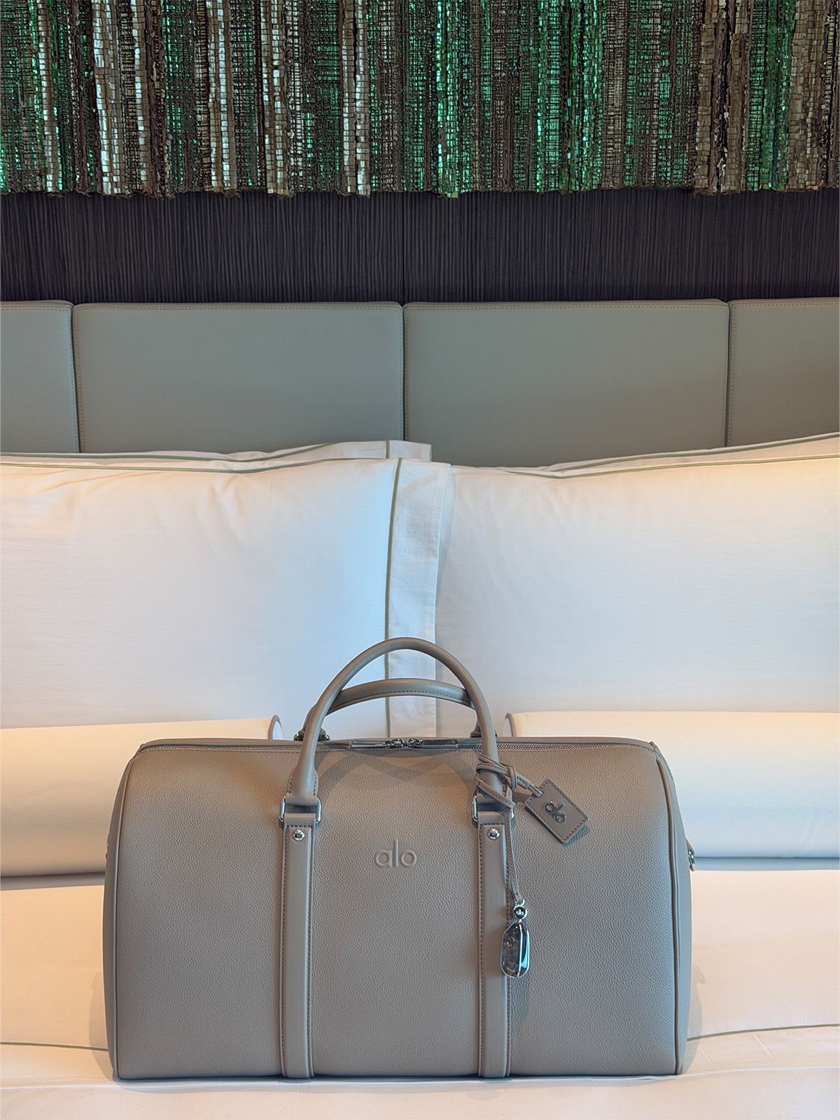 A photo of my bed on the Alo yacht with a new Alo Atelier duffel bag on it.