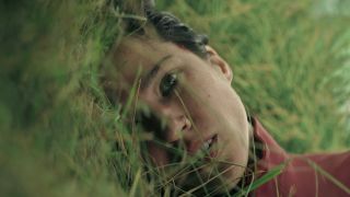 Kelsey Asbille as Iris lying paralyzed in a field of grass in Don't Move