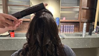 Reviewer having her hair done with a Dyson Airwrap i.d. in a salon