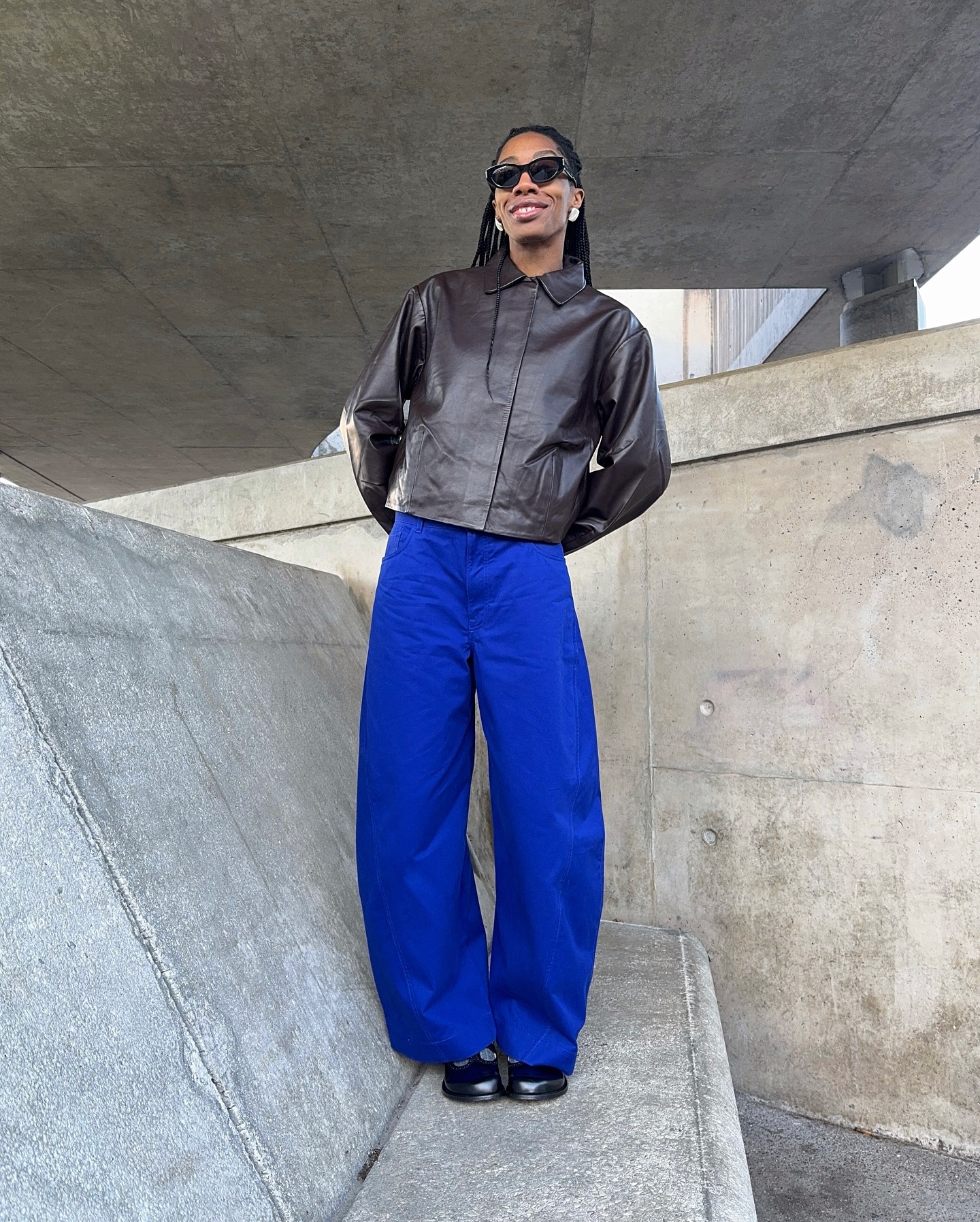 Influencer wears barrel leg trousers.