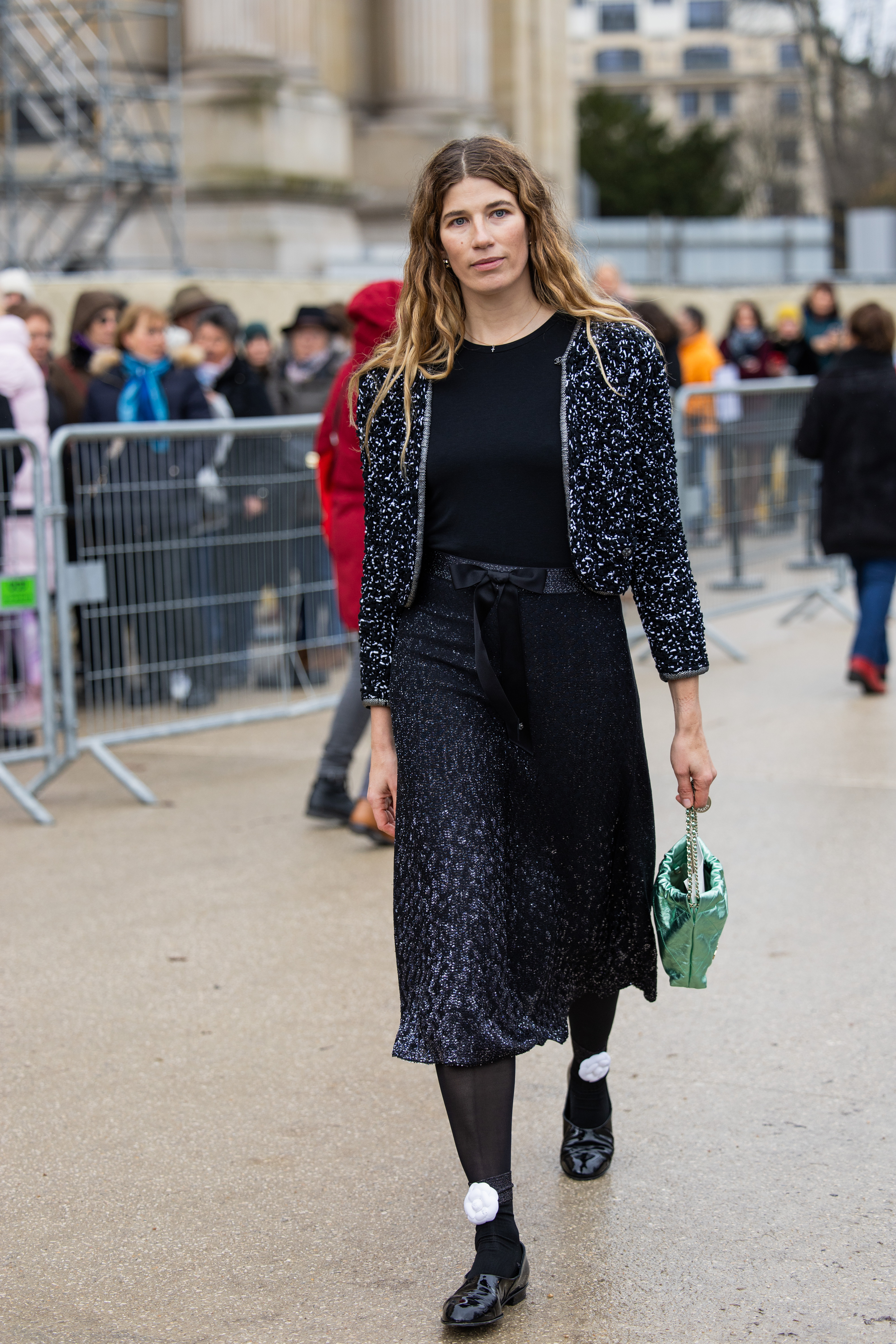 Veronika Heilbrunner usa jaqueta cinza, saia cinza preta de dois tons, bolsa verde metálica do lado de fora da Chanel durante a Haute Couture Spring-Summer 2025 como parte da Paris Fashion Week em 28 de janeiro de 2025 em Paris, França.